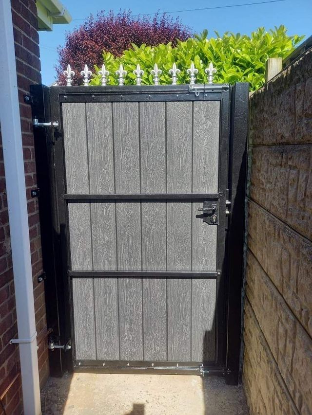 Inside view of an anthracite grey composite pedestrian gate showing the frame, bracing rails and silver fleur de lis