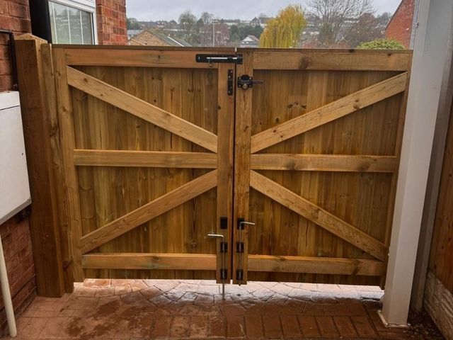 The same carport gates from inside showing the braced frame, drop bolts and the view out over the rooftops