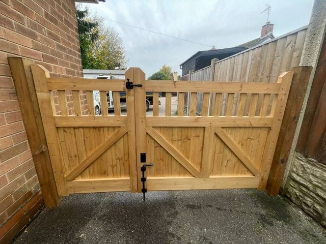 The same offset wooden gates from the other side showing the open spindle top section above a braced boarded lower half