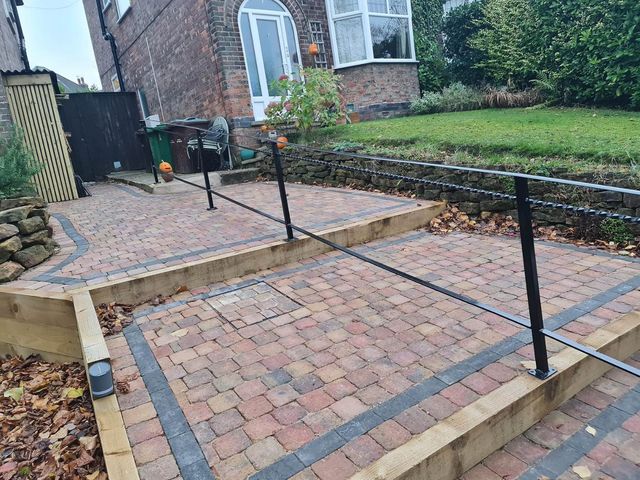Metal handrail used as a divider along a shared access path