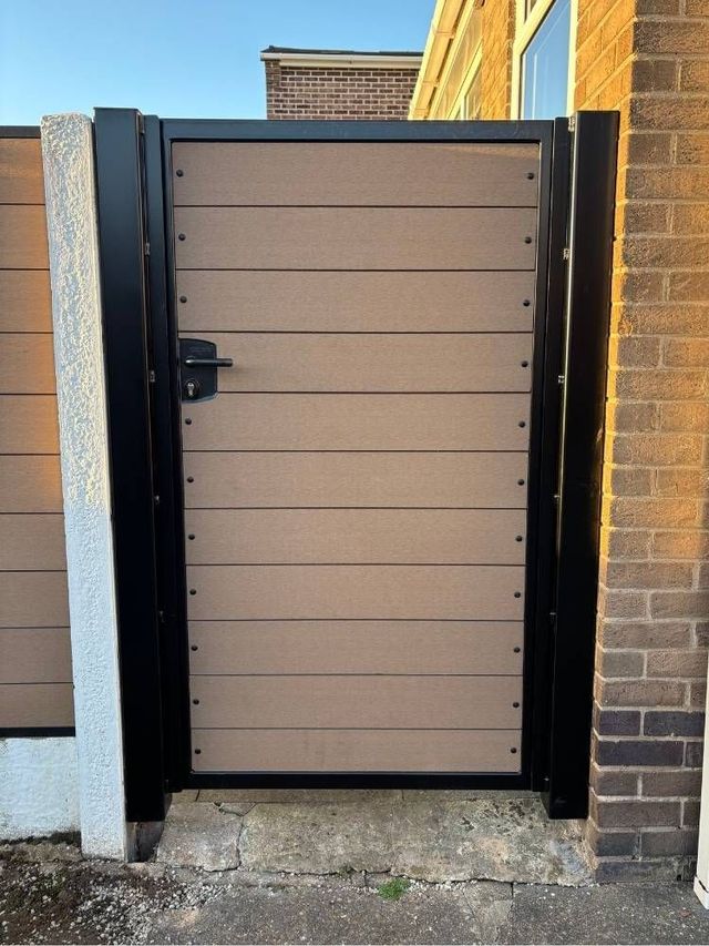Natural coloured composite pedestrian gate with horizontal boards in a black frame