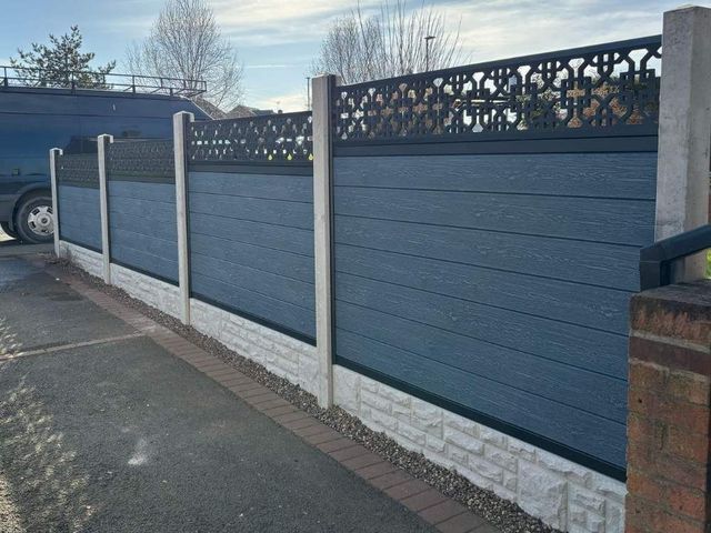 Silver grey composite fencing with cathedral screening on concrete posts and gravel boards