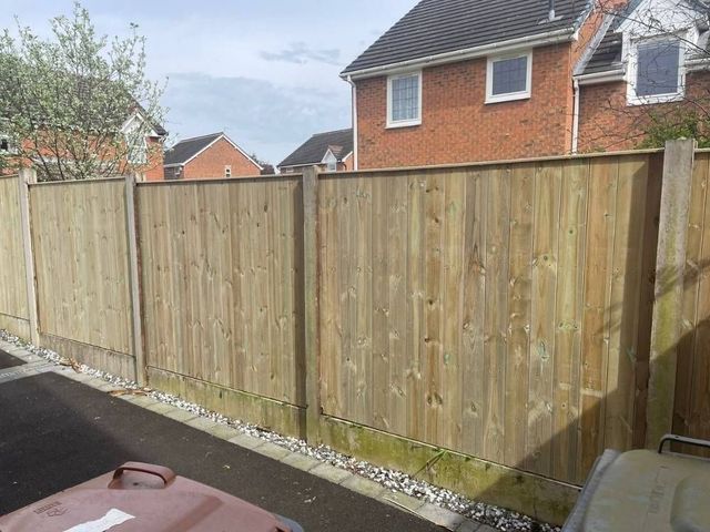 Flat top tongue and groove timber fence panels forming a boundary between two modern houses