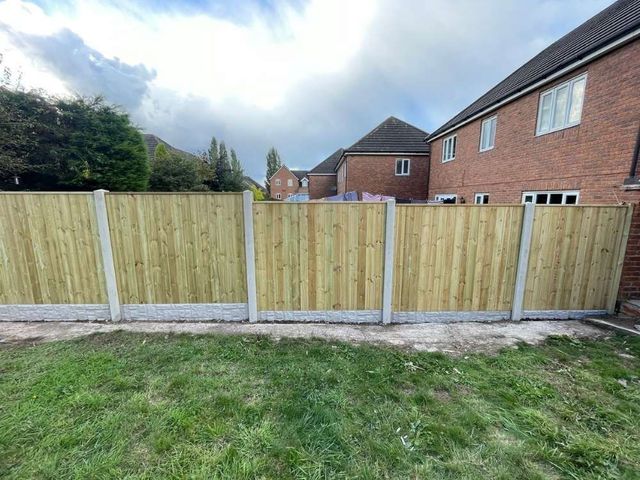 Tongue and groove fence panels fitted into concrete posts with rock faced gravel boards along a rear garden