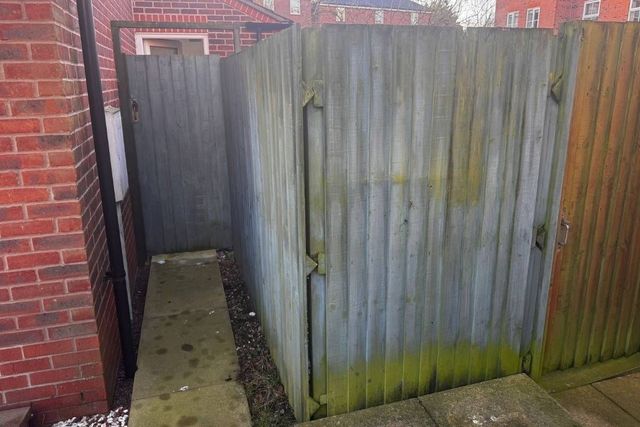 Old grey weathered timber fencing and gate in West Bridgford before replacement