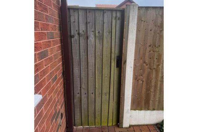 A weathered green timber side gate in West Bridgford before replacement