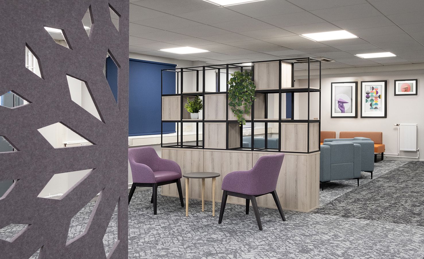 The room is separated by a storage divider with a few plants on it. Against the divider is a small table and two purple soft seats. On the other side of the divider is a lounge area with blue & orange sofas. The fitout was completed by Saxen, a Scotland office furniture fitout company.
