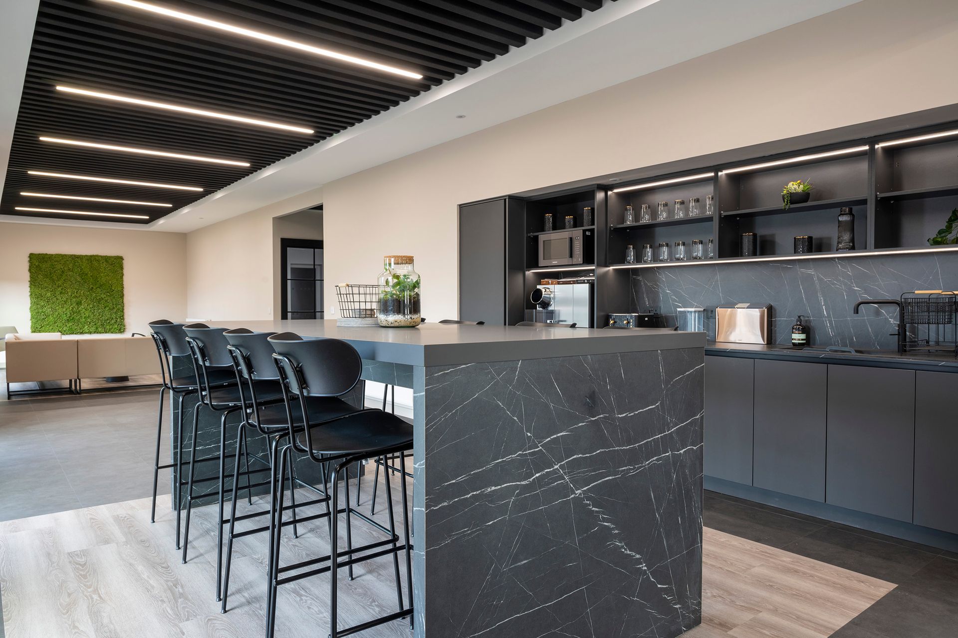 A kitchen with a large island and stools in it