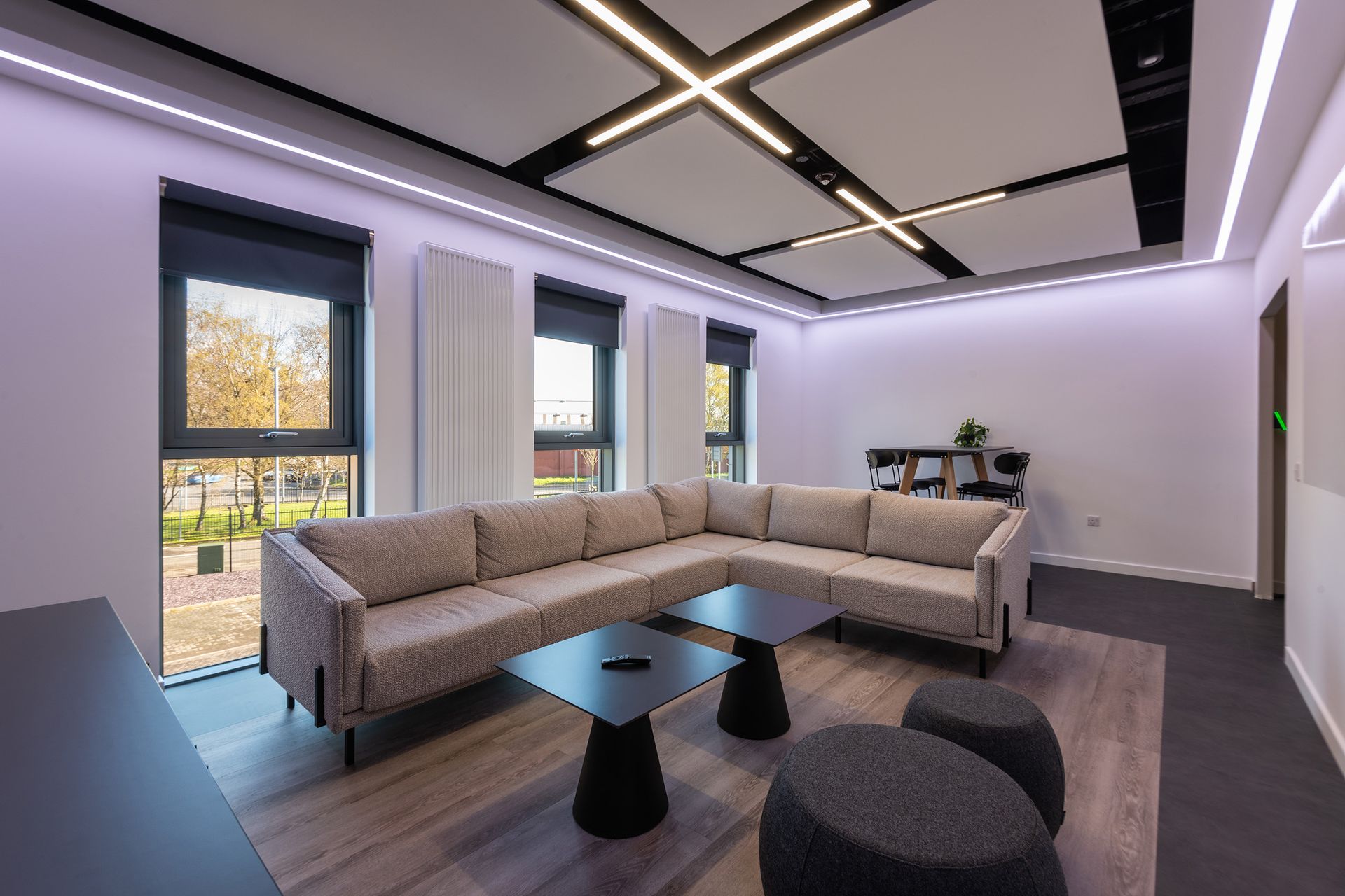 A living room with a couch , coffee table , and ottomans.