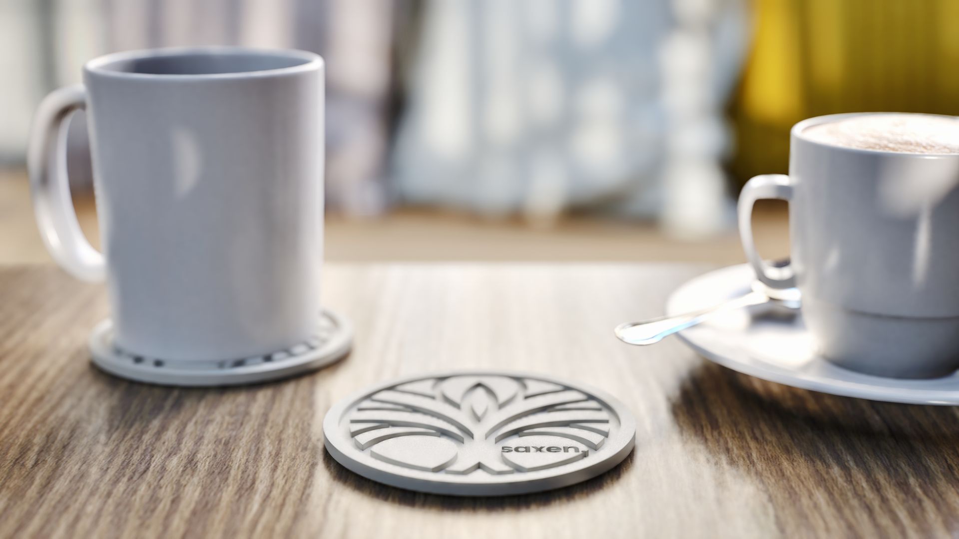 Two mugs, one on a coaster with a tree design, on a wooden table.