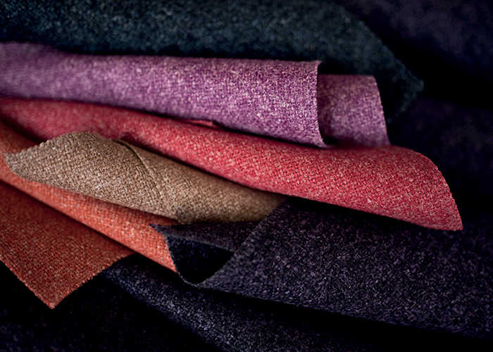 Colorful wool fabric swatches, various hues, arranged in a stack.