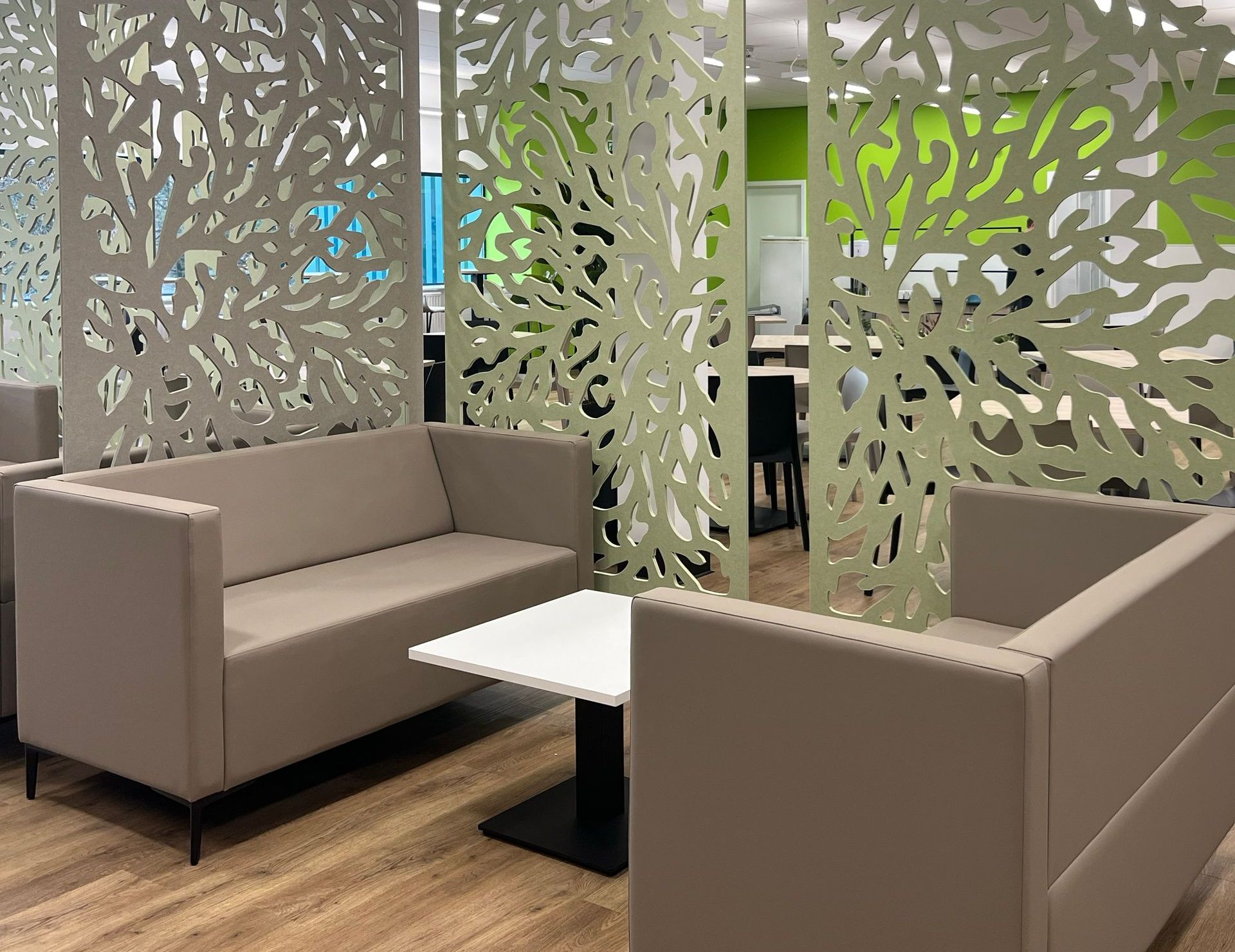 Autex acoustic ceiling-hung screens in a modern canteen space with soft seating, coffee table and planters,