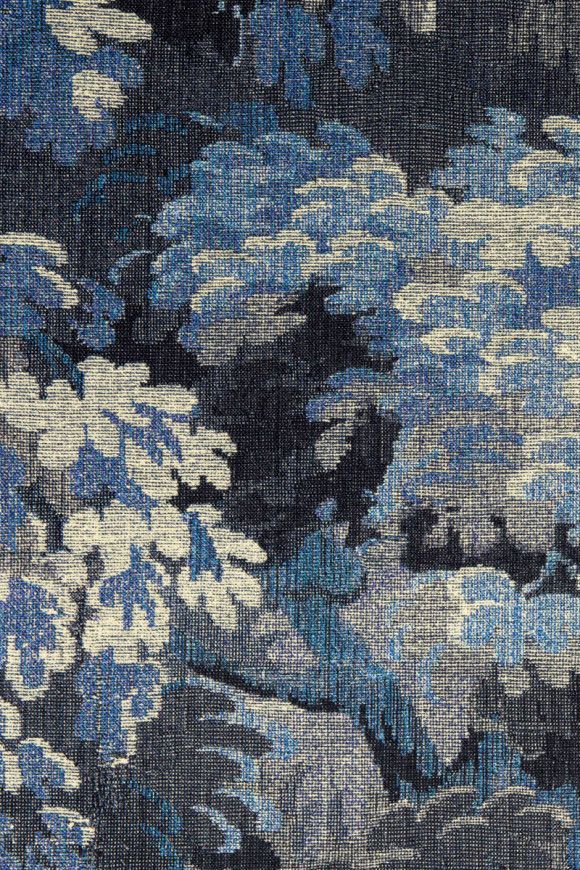 Textured fabric with blue floral pattern on a dark background.