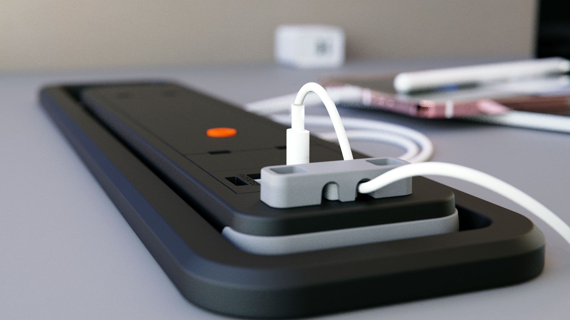 A black and gray charging station with a white charging cable plugged in on a desk.