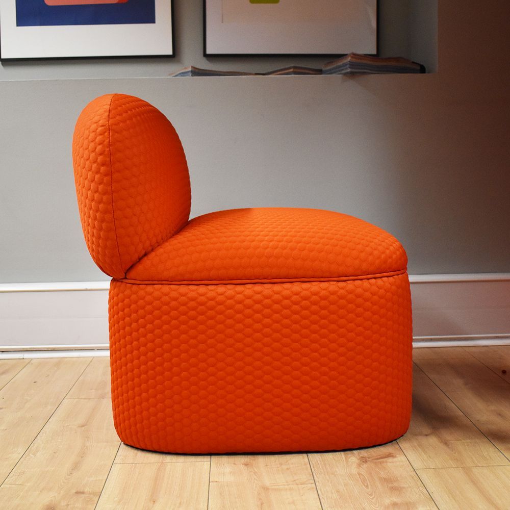 Orange upholstered chair with a quilted texture.