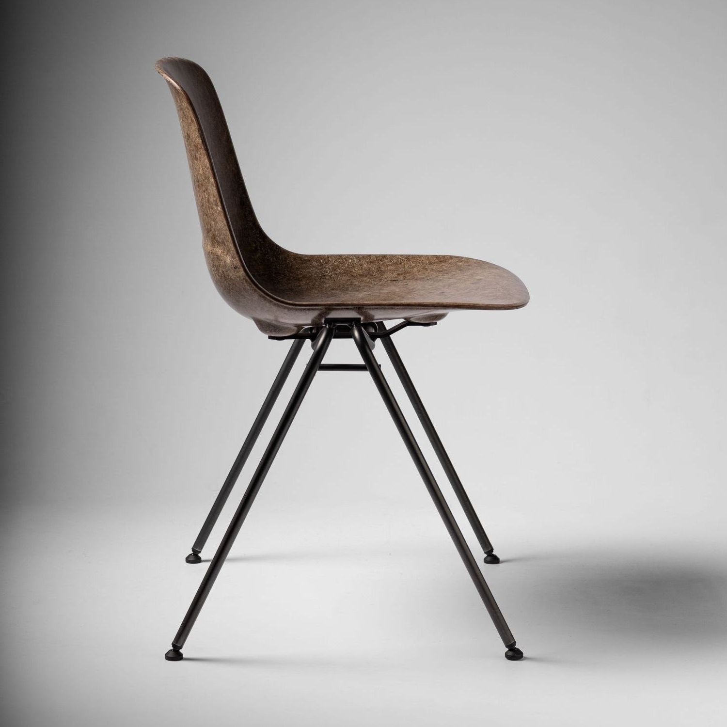 Hazel Welsh Mountain Solidwool Shell chair with black steel legs facing right.