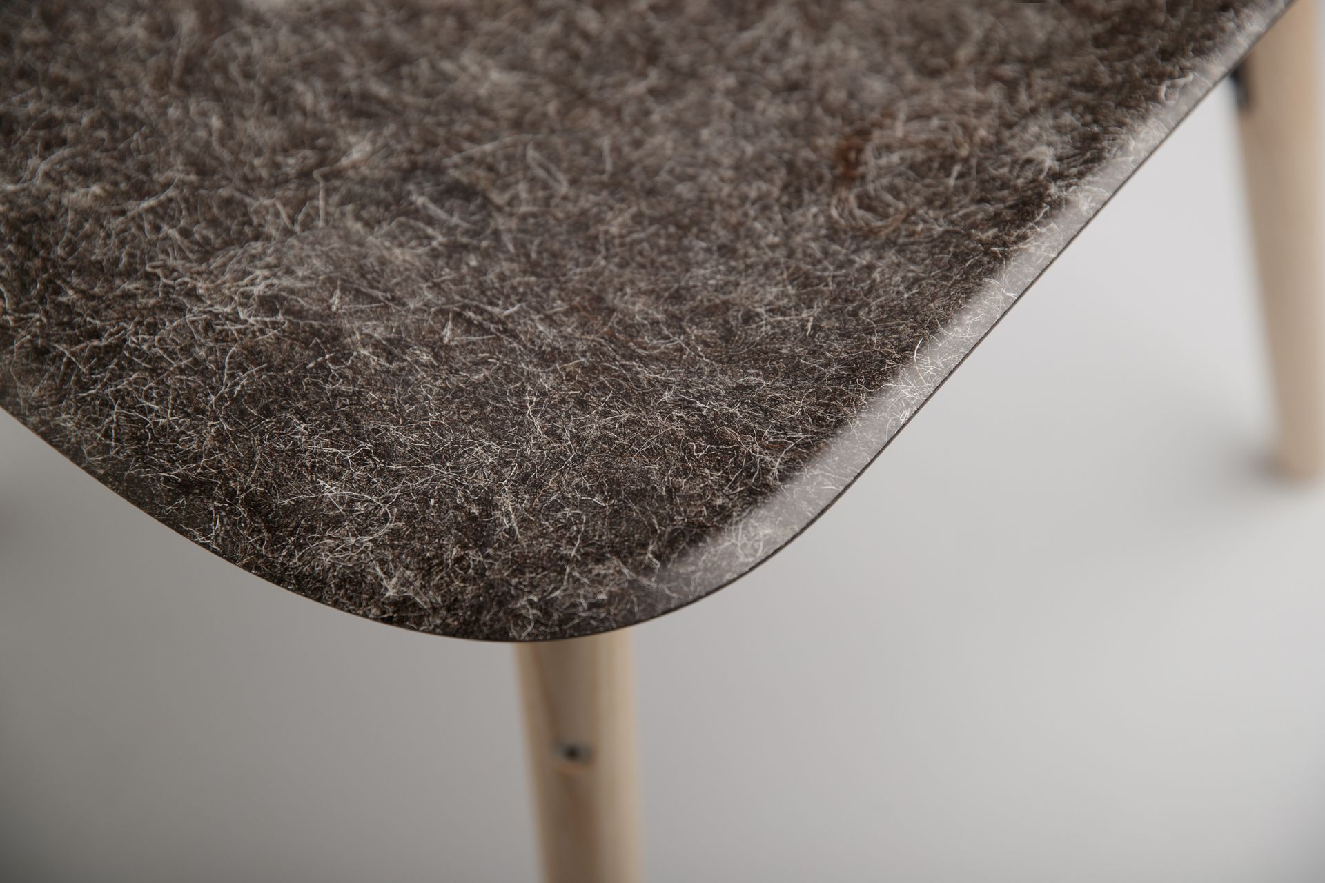 Close up of Hembury chair using Herdwick sheep wool. The colour is a dark grey with white lining throughout.
