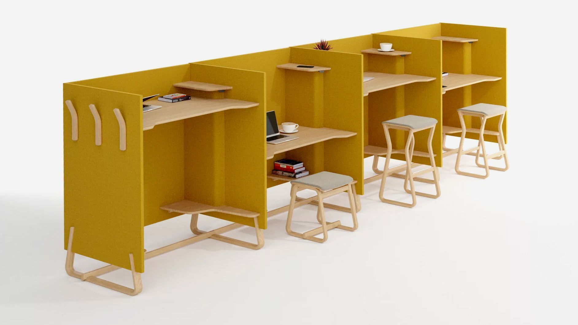 Theo study booths are mustard yellow. The tabletops are adjustable, so you can sit or stand at the desk or use a stool. Laptops, mugs, books, etc., are on each desk.