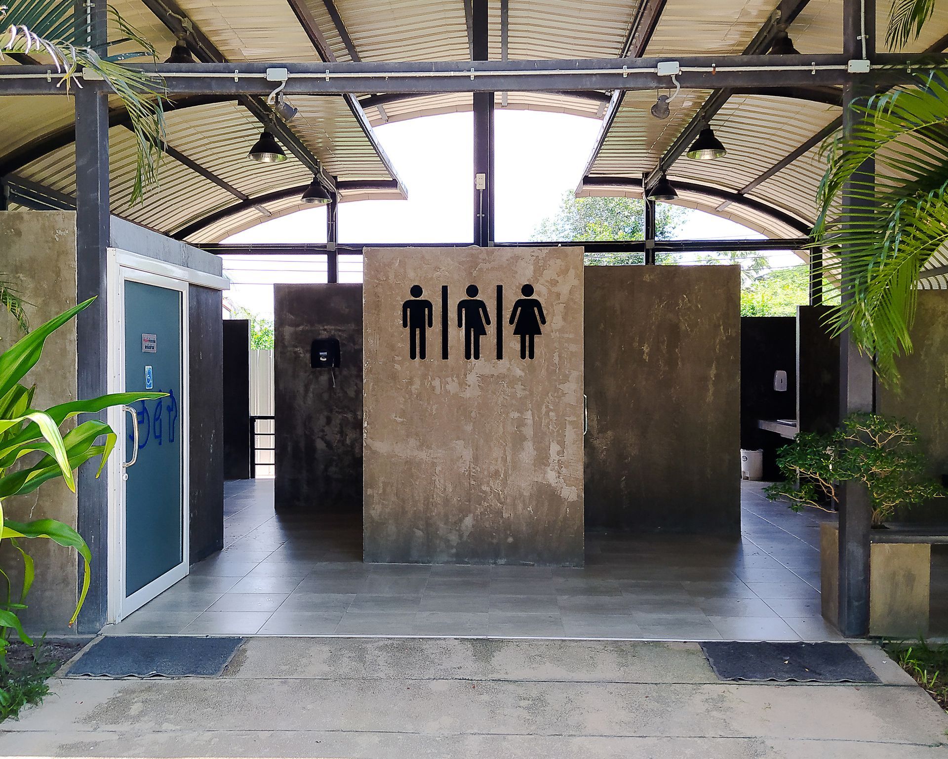 A modern and naturally-lit corner of an office with accessible bathrooms for men, women, and gender-neutral people. There is also an accessible bathroom to the left for wheelchair users, people with disabilities, and for baby-changing.