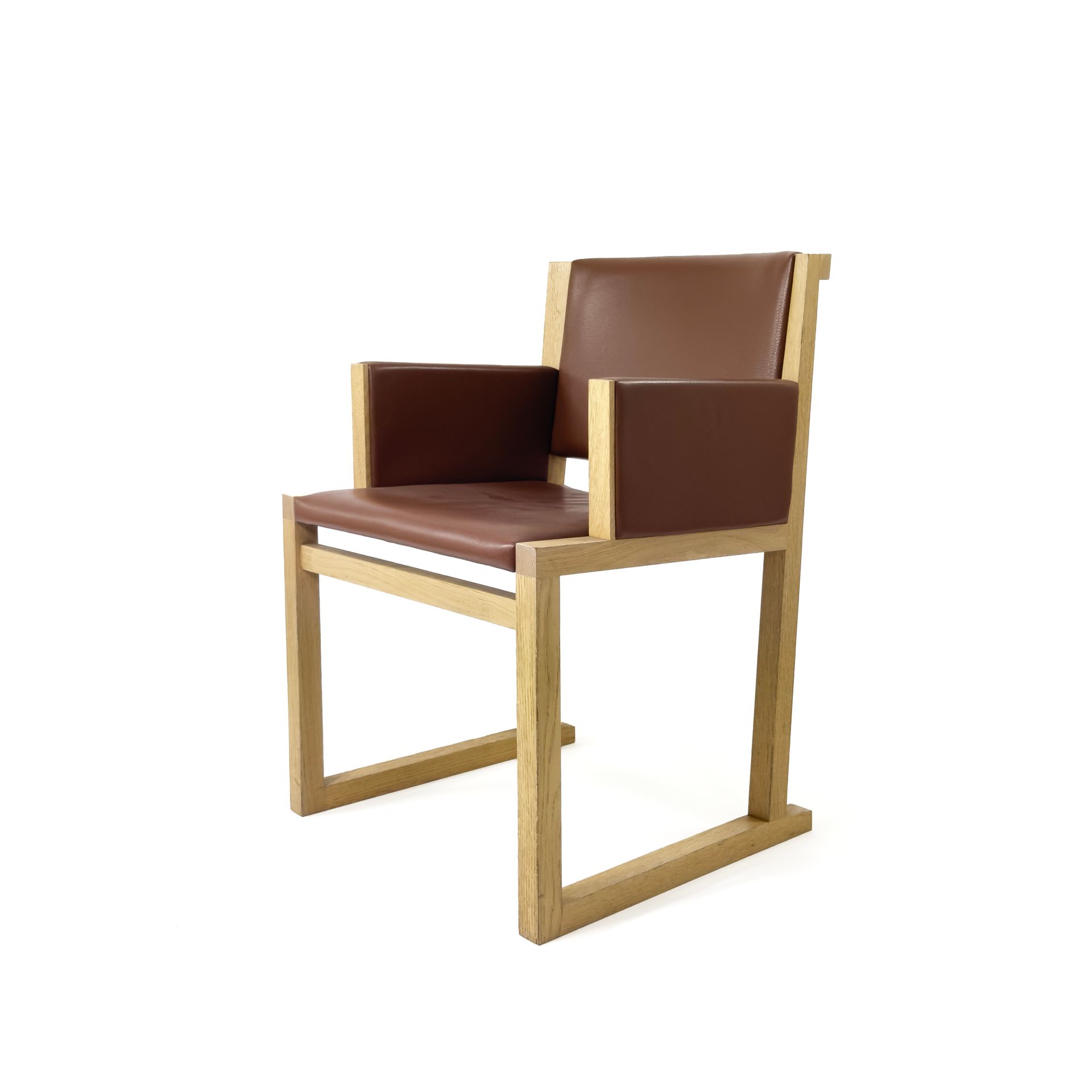 Brown leather and wood armchair against a white background.