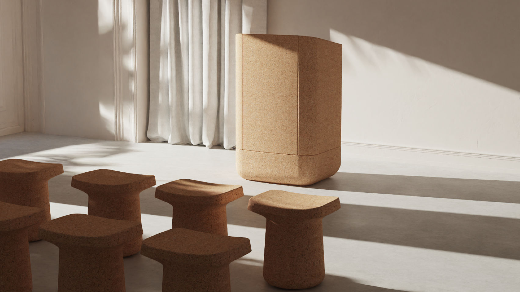 Cork speaker and stools in a bright room with curtains, lit by sunlight.