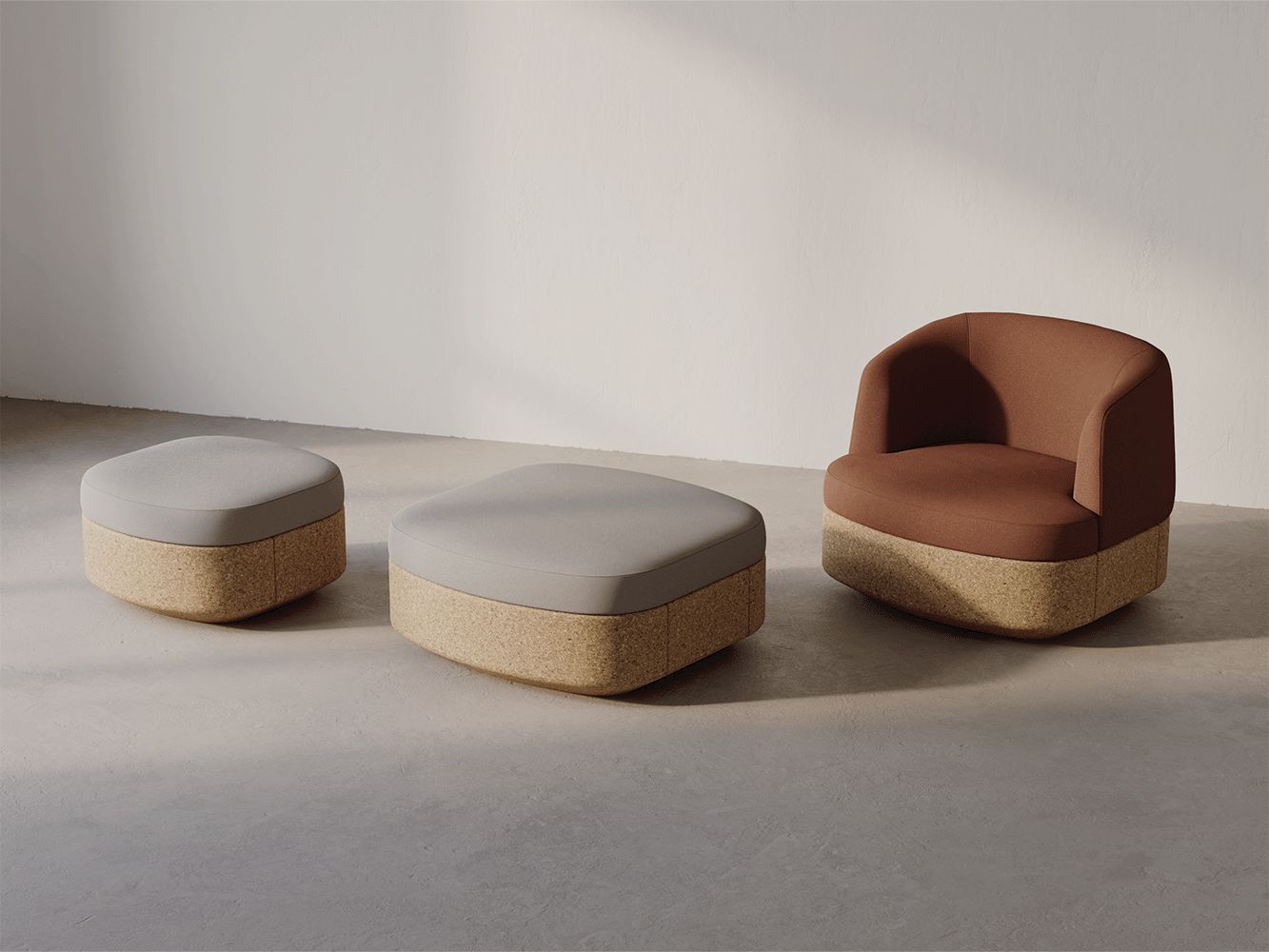 A brown armchair and two ottomans with cork bases and light gray/brown seating, set against a white wall.