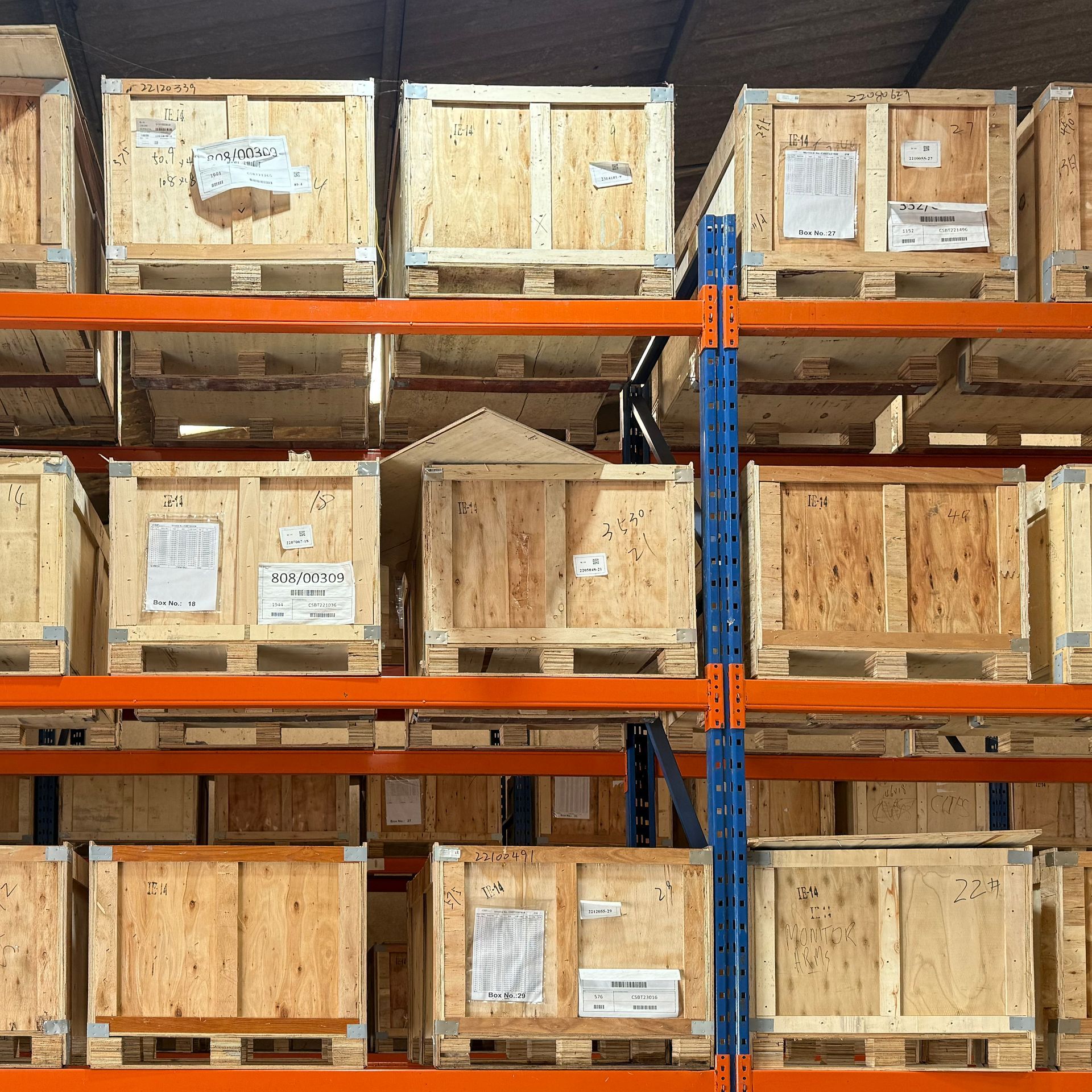Wooden crates stacked on orange shelves in a Scottish warehouse.