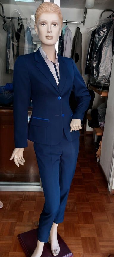 Maniquí de mujer con chaqueta azul marino y blusa color lila con ribete azul