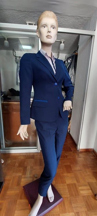 Maniquí de mujer vestida con chaqueta azul marino y blusa color lila