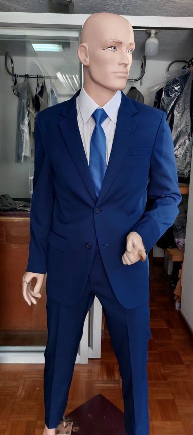 Maniquí de hombre vestido con chaqueta azul marino, camisa blanca y corbata azul.