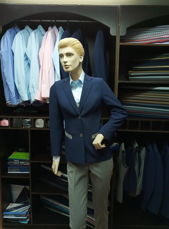 Maniquí de mujer vestida con chaqueta azul marino y blusa celeste
