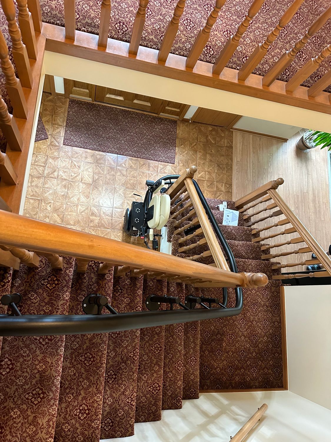 Spiral staircase in a brown-and-beige interior, viewed from above.
