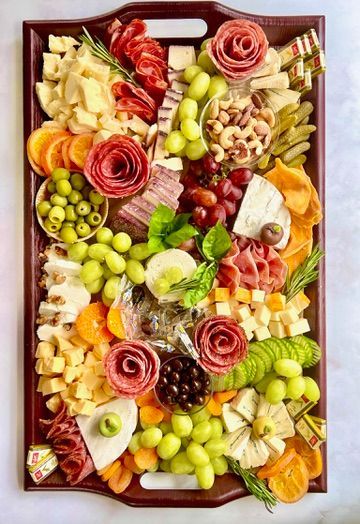 A wooden tray filled with lots of different types of food.