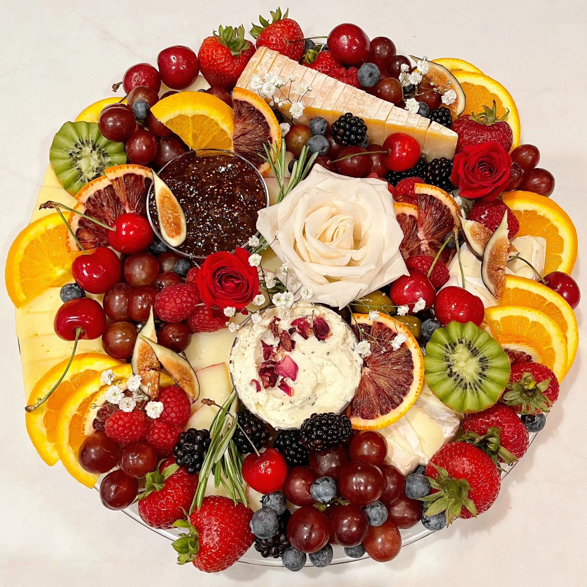 A plate filled with fruit and cheese on a table