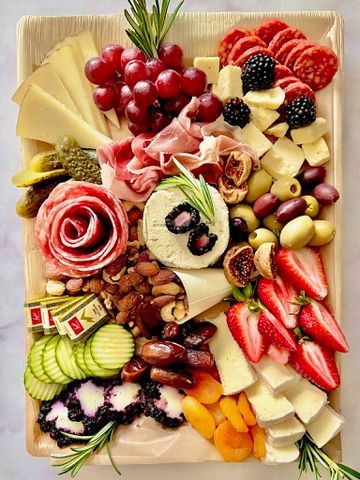 A wooden cutting board filled with lots of different types of food.