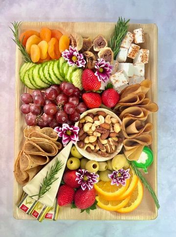 A wooden cutting board topped with a variety of fruits and vegetables.