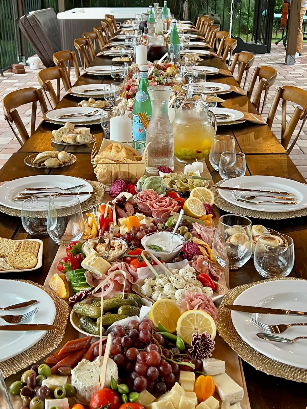 A long wooden table topped with plates of food and utensils.