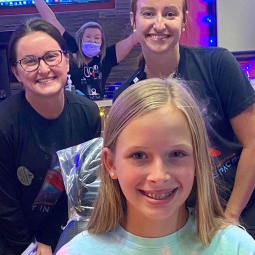 A group of women and a young girl are posing for a picture.