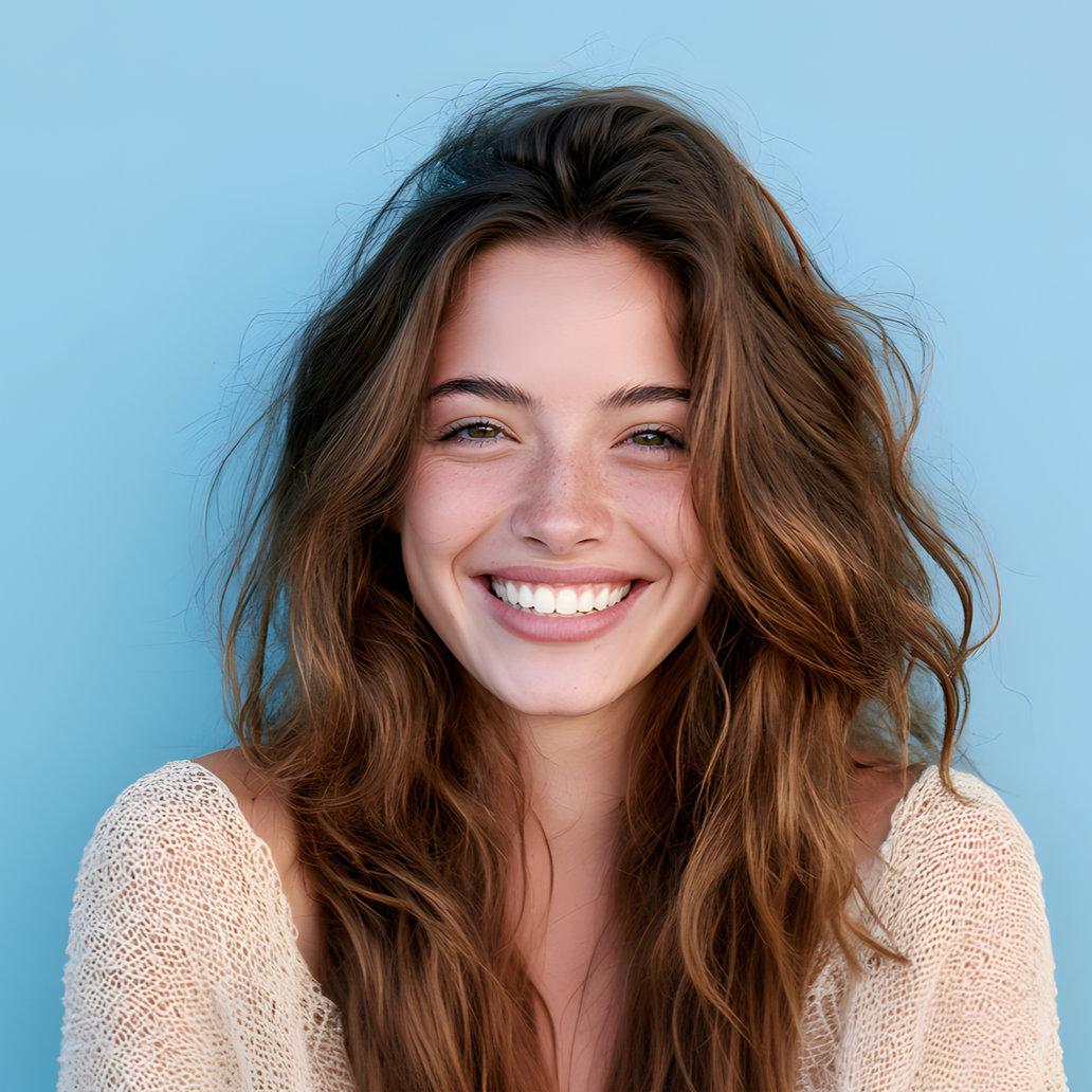 Smiling woman with wavy brown hair against a light blue background