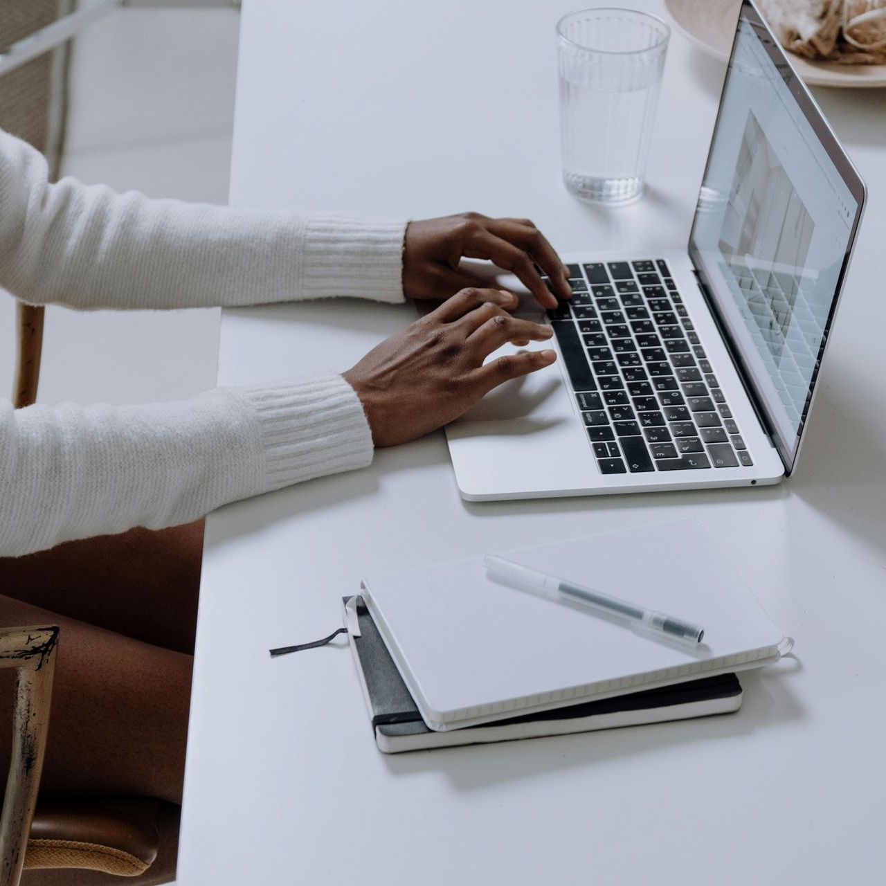 A person is typing on a laptop computer at a desk