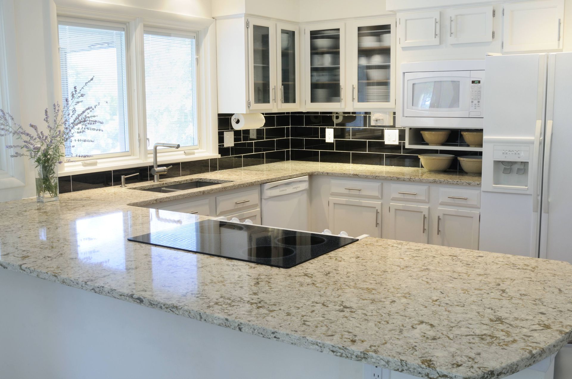 a kitchen with granite counter tops and white cabinets