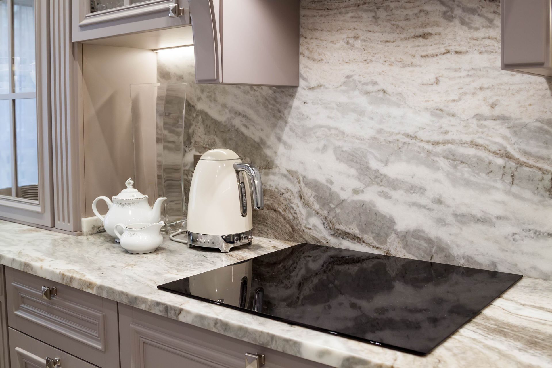 a kitchen with a stove top oven , a kettle , and a teapot on the counter