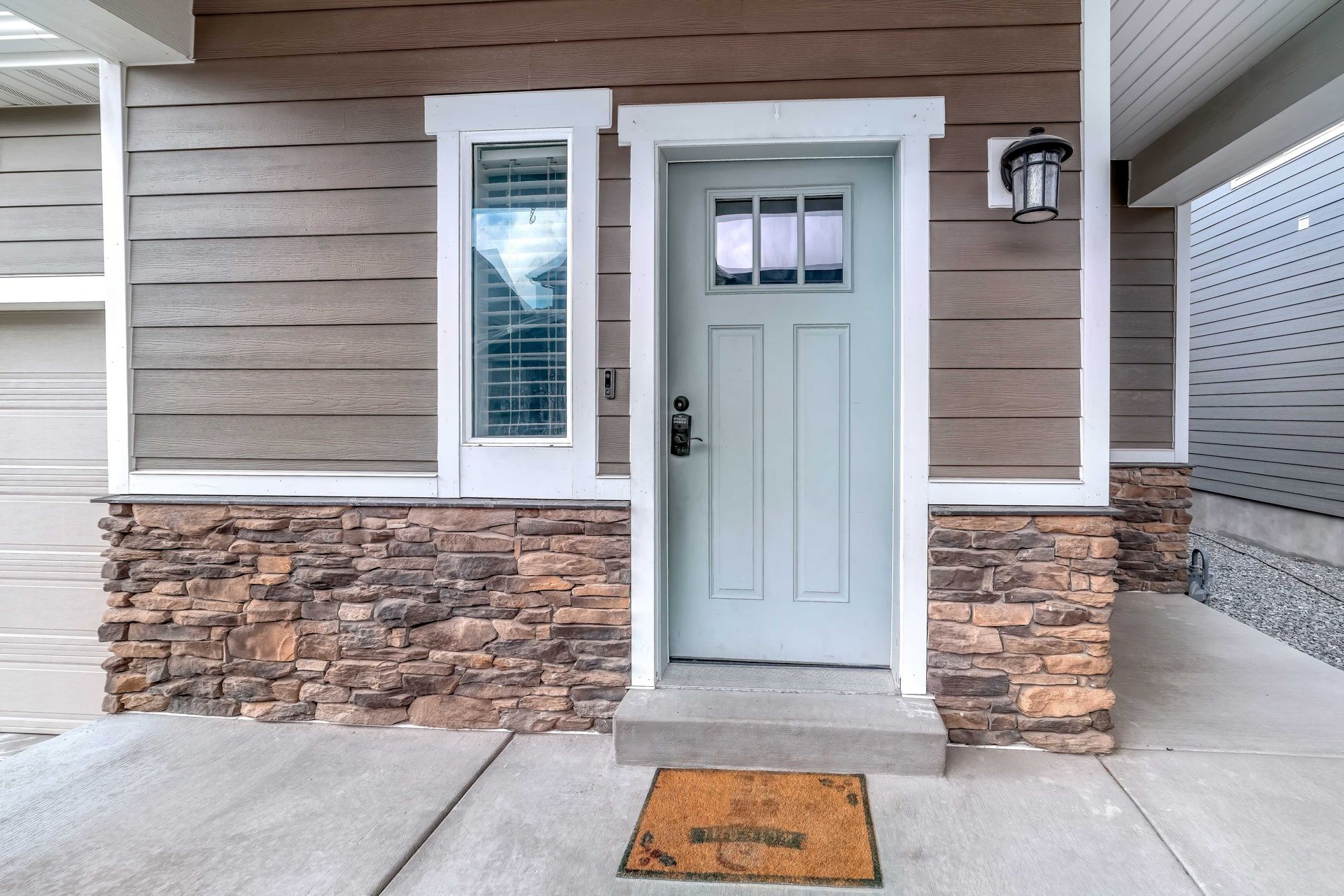 the front door of a house with a welcome mat in front of it