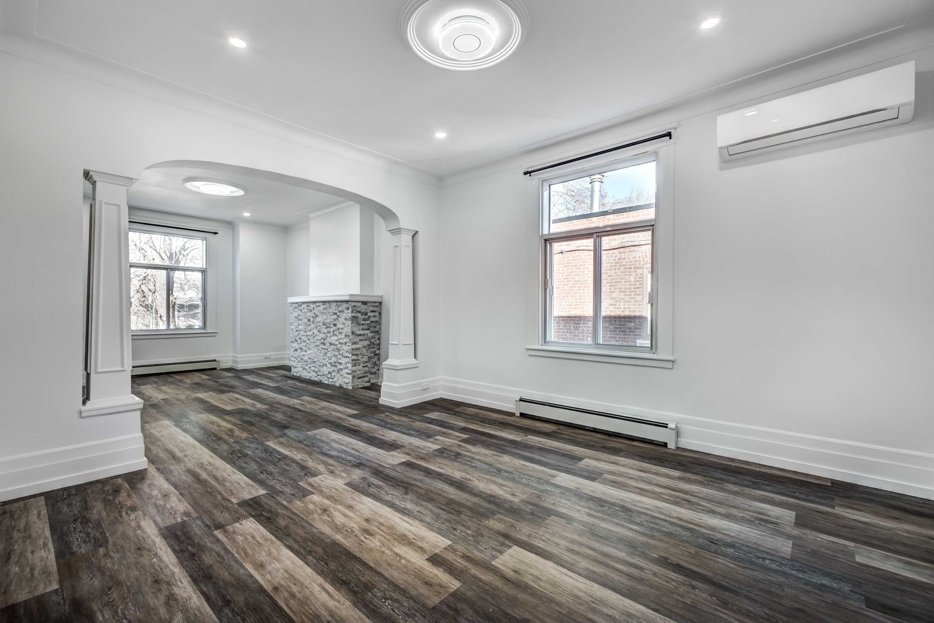 an empty living room with hardwood floors and white walls