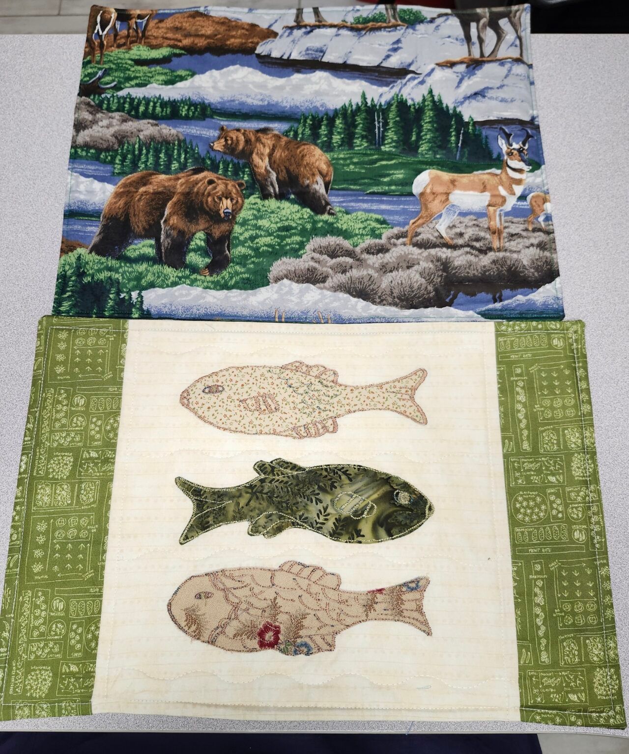 Two pieces of fabric with bears and fish on them