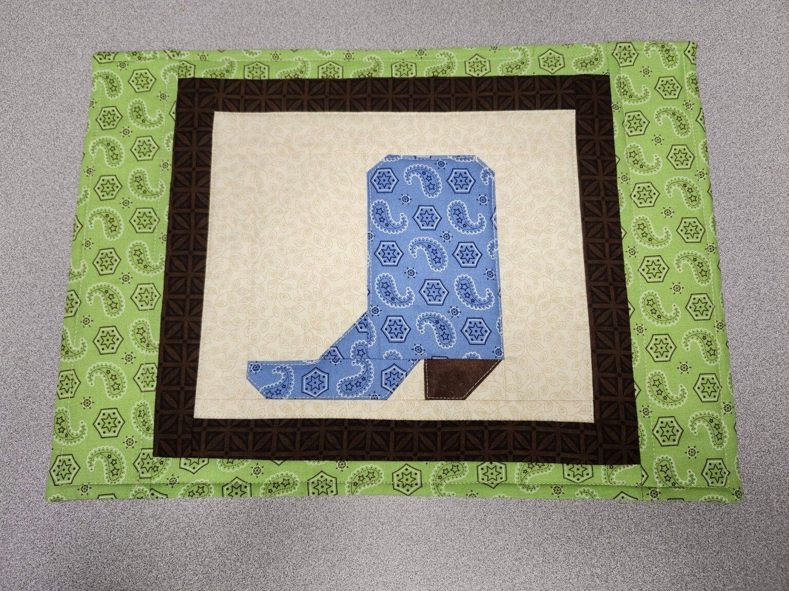 A quilt with a blue cowboy boot on it