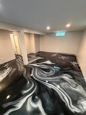 Empty room with black-and-white swirled flooring and recessed ceiling lights