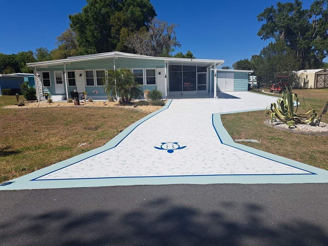 A house with a white driveway and a blue turtle painted on it.