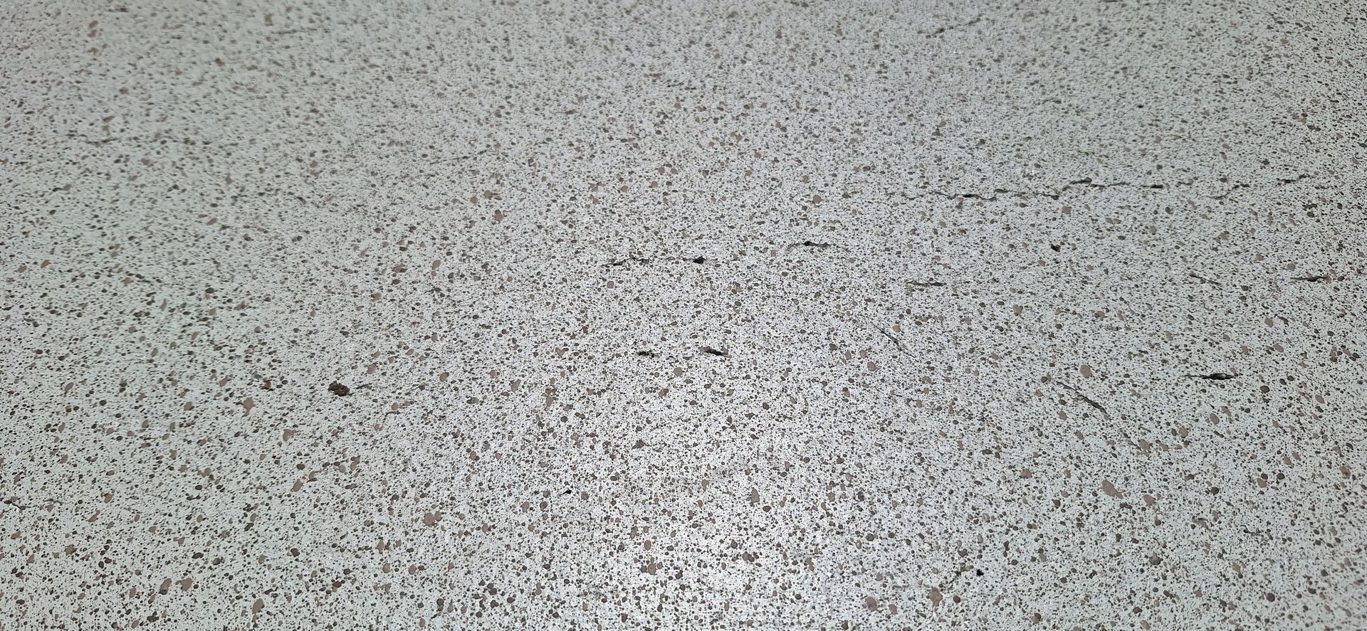 A close up of a gray carpet with a lot of small dots on it.