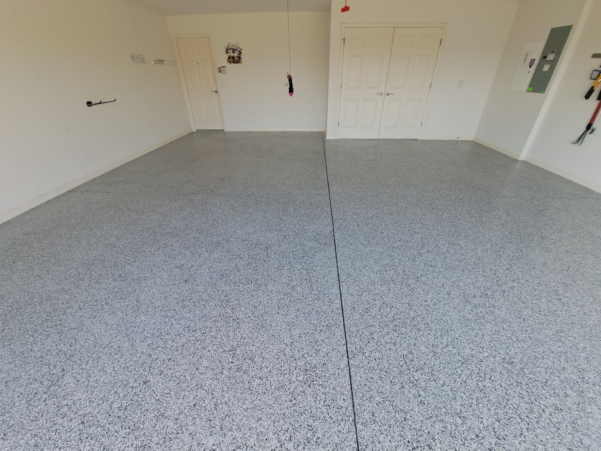A garage with a gray floor and white walls.